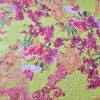 Țesătură cu suprafața paietata și imprimata floral pe fond galben